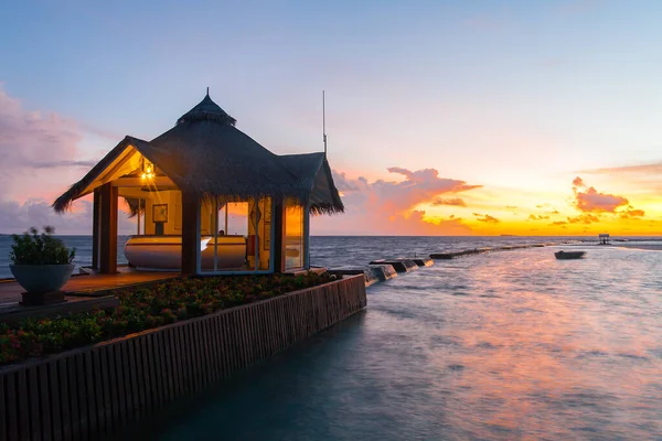 Puesta de sol en isla tropical, complejo de villas acuáticas — Foto de Stock