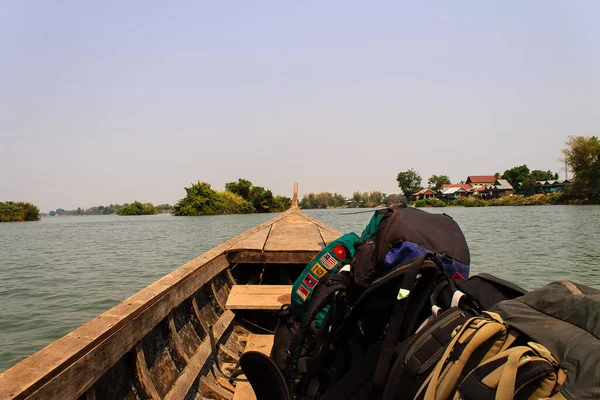Tahta tekne Mekong Nehri 'nde seyahat ediyor. Sırt çantalı Mekong Nehri 'ndeki Ulaşım Örneği Laos