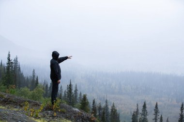 Bir dağ manzarasının arka planında bir adam