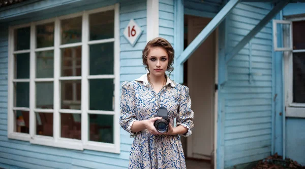 Femme en robe vintage avec caméra rétro à la main — Photo