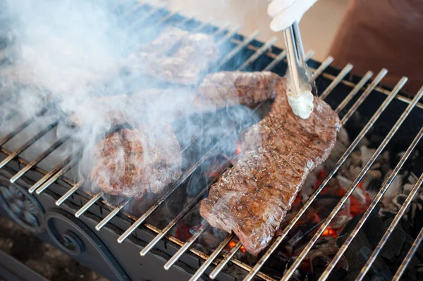 Kuchařka zapečené steaky z mramorované maso na gril pánev — Stock fotografie