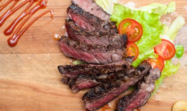 Sulu biftek mermer sığır eti üzerinden bir ahşap tahta üzerine dilimlenmiş