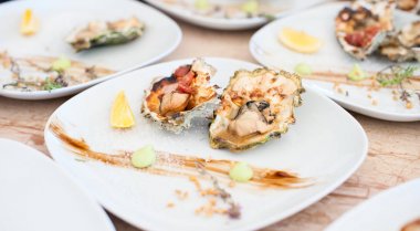 Beyaz bir plaka üzerinde bir ızgara yalan üzerinde istiridye pişmiş