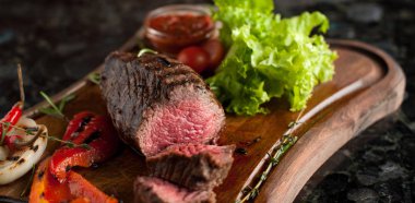 Sulu kıyılmış biftek chateaubriand bir ahşap tahta üzerinde sebze ile mermer Dana eti