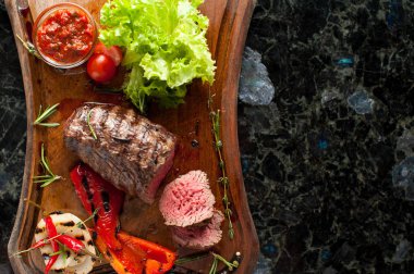 Sulu kıyılmış biftek chateaubriand bir ahşap tahta üzerinde sebze ile mermer Dana eti