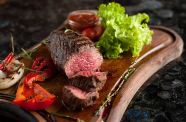 Sulu kıyılmış biftek chateaubriand bir ahşap tahta üzerinde sebze ile mermer Dana eti