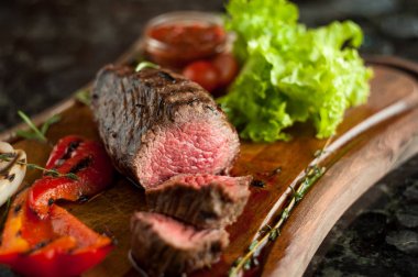 Sulu kıyılmış biftek chateaubriand bir ahşap tahta üzerinde sebze ile mermer Dana eti