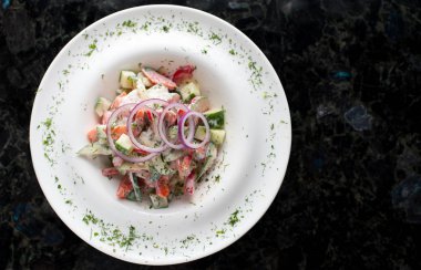 Beyaz tabakta sebze salatası.