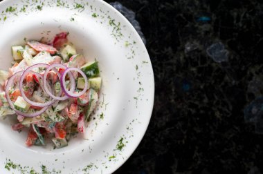 Beyaz tabakta sebze salatası.