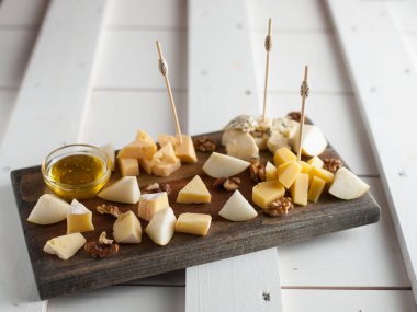 Peynir bal ve fındık ile çeşitli çeşitli. Bir koyu ahşap tahta üzerine yerleştirilmiş