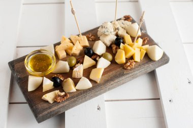 Peynir bal ve fındık ile çeşitli çeşitli. Bir koyu ahşap tahta üzerine yerleştirilmiş