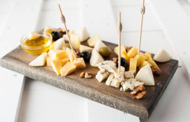 Peynir bal ve fındık ile çeşitli çeşitli. Bir koyu ahşap tahta üzerine yerleştirilmiş