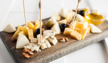 Peynir bal ve fındık ile çeşitli çeşitli. Bir koyu ahşap tahta üzerine yerleştirilmiş