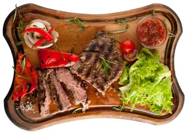 Ahşap oyun tahtası sebzeli mermer sığır eti gelen sulu biftek. Dilimlenmiş. İzole