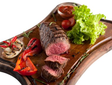Ahşap oyun tahtası sebzeli mermer sığır eti gelen sulu biftek. Dilimlenmiş. İzole
