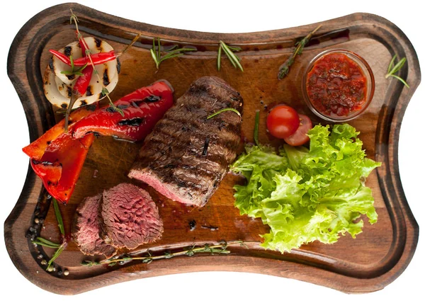 Ahşap oyun tahtası sebzeli mermer sığır eti gelen sulu biftek. Dilimlenmiş. İzole