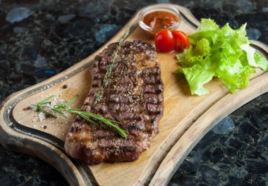 Bir ahşap tahta üzerinde mermer sığır eti sulu biftek