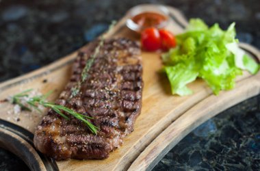 Bir ahşap tahta üzerinde mermer sığır eti sulu biftek