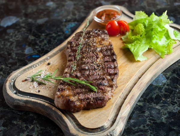 Egy fából készült hajón márványos Marhahúsból készült, szaftos steak — Stock Fotó
