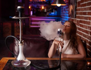 Beyaz bir bluz kız güzel bir nargile bar iç sigara içiyor.