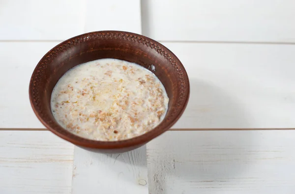 Gachas de trigo sarraceno con leche, mantequilla y perejil fresco en un tazón hondo — Foto de Stock