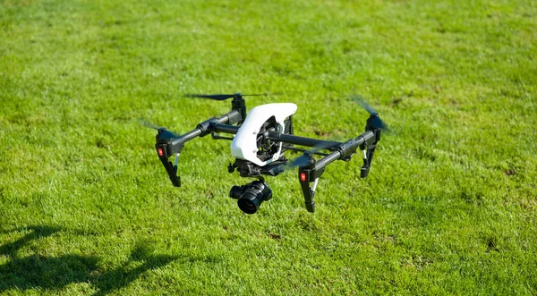 Quadrocopter with camera on a background of green grass — Stock Photo, Image