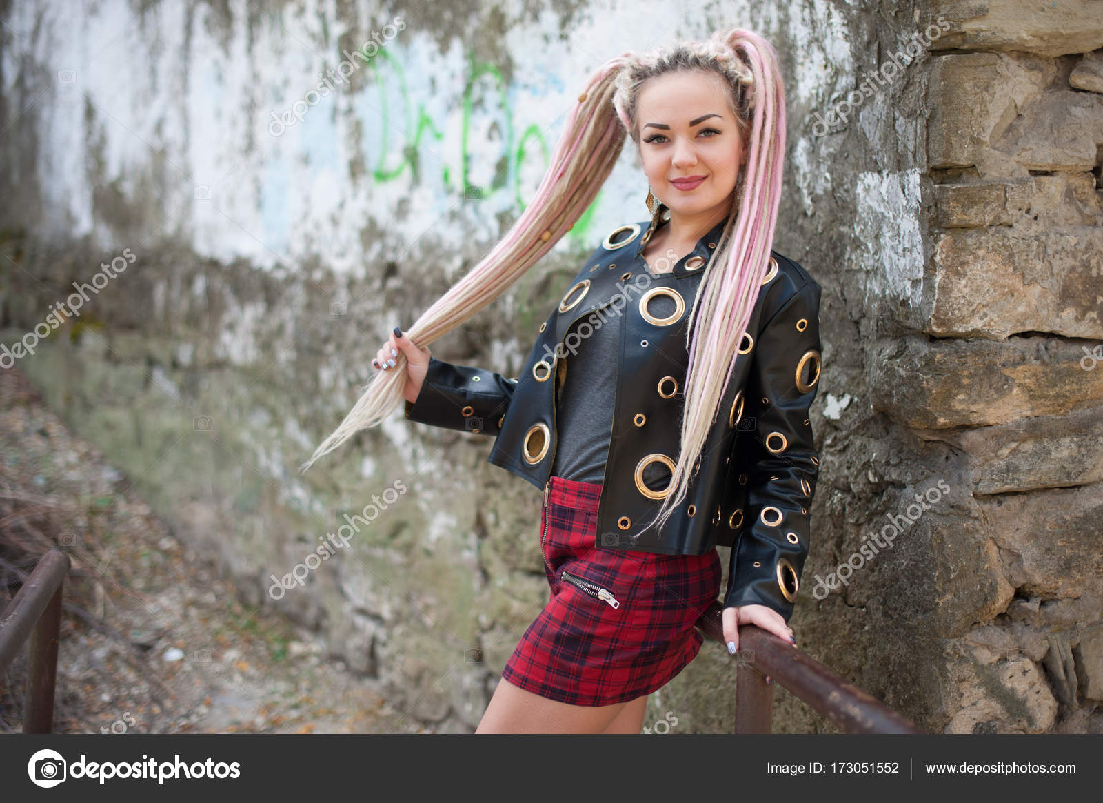 A Girl With Dreadlocks In A Leather Jacket And A Short Skirt