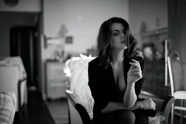 Zwart-wit portret van een rookvrije meisje tegen de achtergrond van het interieur van een appartement. Stijl noir — Stockfoto
