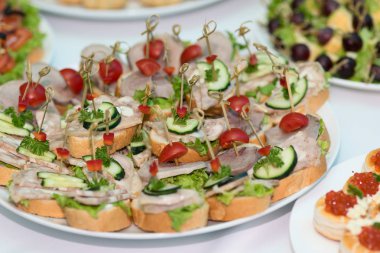 Açık büfe. Çeşitli aperatifler ve kanepeler plakaları. Jambon, taze salatalık ve domates ile snack