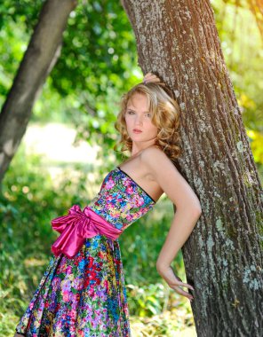 Yaz parkta poz parlak renkli elbiseli genç sarışın kız