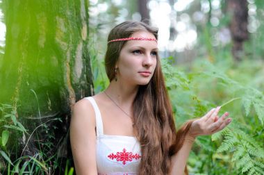 Uzun saçlı ve bir yaz ormandaki Slav etnik elbise genç güzel bir Slav kız portresi