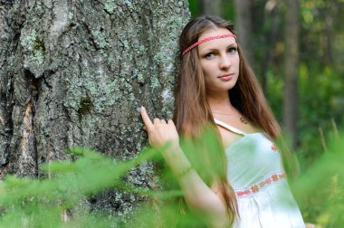 Uzun saçlı ve bir yaz ormandaki Slav etnik elbise genç güzel bir Slav kız portresi