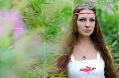 Uzun saçlı ve uzun otların çalılıkları Slav etnik elbise genç güzel bir Slav kız portresi