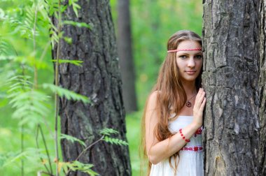 Uzun saçlı ve bir yaz ormandaki Slav etnik elbise genç güzel bir Slav kız portresi
