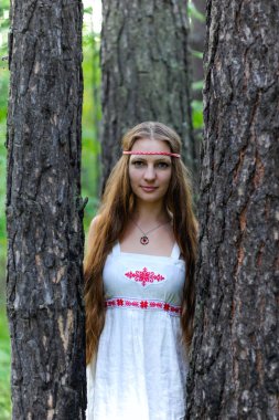 Uzun saçlı ve bir yaz ormandaki Slav etnik elbise genç güzel bir Slav kız portresi