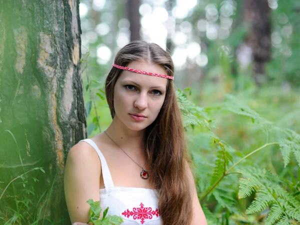 Portrait of a young beautiful Slavic girl with long hair and Slavic ethnic dress in a summer forest — Stock Photo, Image