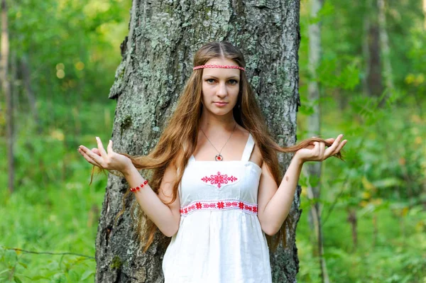 Uzun saçlı ve bir yaz ormandaki Slav etnik elbise genç güzel bir Slav kız portresi