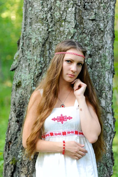 Portrait d'une jeune belle fille slave aux cheveux longs et robe ethnique slave dans une forêt d'été — Photo