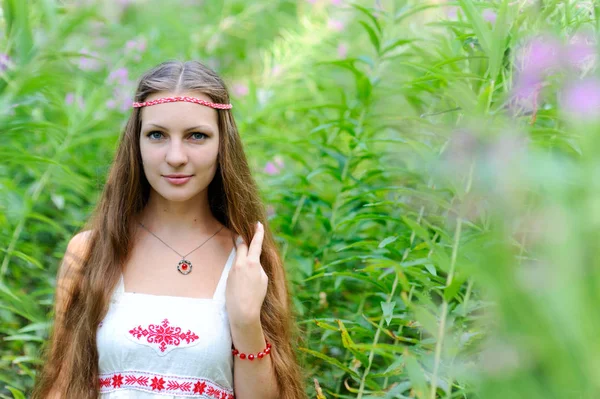 Uzun saçlı ve uzun otların çalılıkları Slav etnik elbise genç güzel bir Slav kız portresi