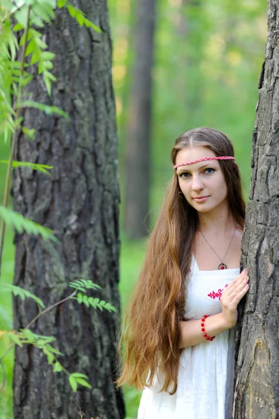 Uzun saçlı ve bir yaz ormandaki Slav etnik elbise genç güzel bir Slav kız portresi