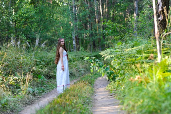 美しいスラブ少女の長い髪とスラヴ民族の服装夏の森のトレイルを歩いて — ストック写真