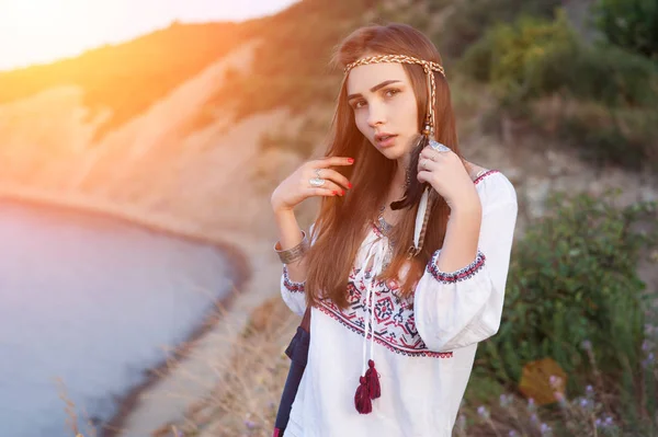 Красива дівчина брюнетка в Bocho шикарний стиль стоїть на тлі моря в променях Яскраве сонце — стокове фото