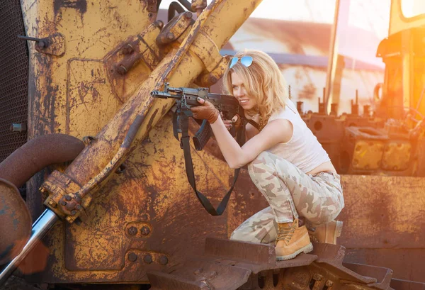Mit Gewehr bewaffnet zielt Frau in die Strahlen einer hellen Sonne — Stockfoto