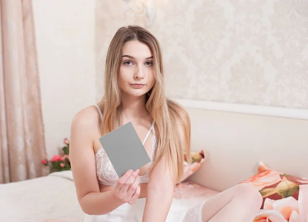Sexy model dziewczyna w bieliźnie pokazuje fotograf szarej karty — Zdjęcie stockowe