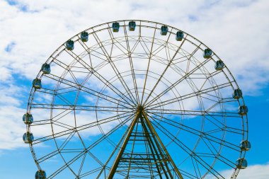 Dönme dolap mavi gökyüzü ve beyaz bulutlar karşı