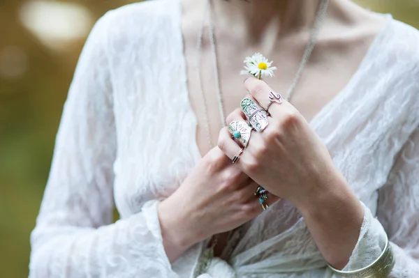 Uma menina hippie em ornamentos do chique Boh vestida com roupas de renda está segurando uma flor margarida — Fotografia de Stock