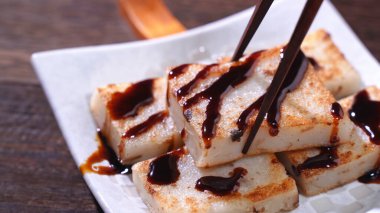 Lezzetli şalgam kekinin üzerine kara soya sosu dök restoranda geleneksel Çin turplu keki, kapat, uzayı kopyala.