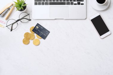 Akıllı telefonlu kredi kartı ile çevrimiçi ödeme kavramı, ofis masasında dizüstü bilgisayar temiz mermer masa arka planı, üst görünüm, düz yatış