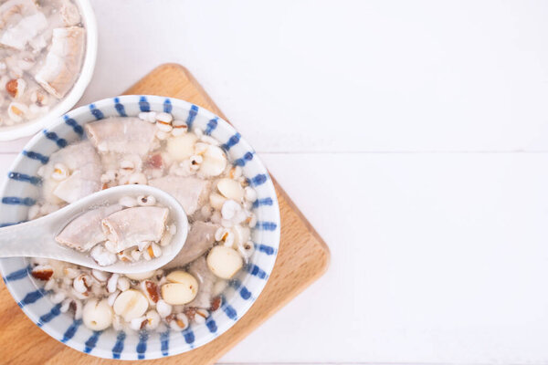 Tasty Four Tonics Herb Flavor Soup,Taiwanese traditional food with herbs,pork intestines on white wooden table,close up,flat lay,top view