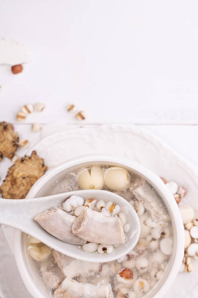 Tasty Four Tonics Herb Flavor Soup, Taiwanese traditional food with herbs, pork intestines on white wooden table, close up, flat lay, top view
